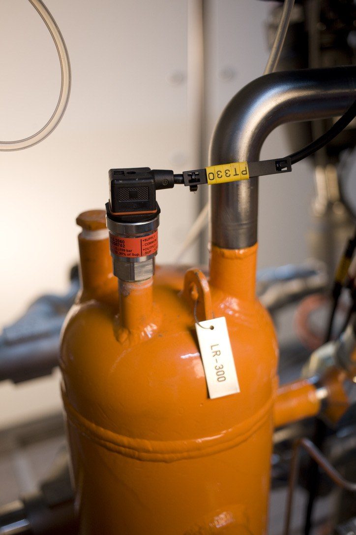Orange-painted refrigerant receiver with a pressure transmitter and a numbered tag