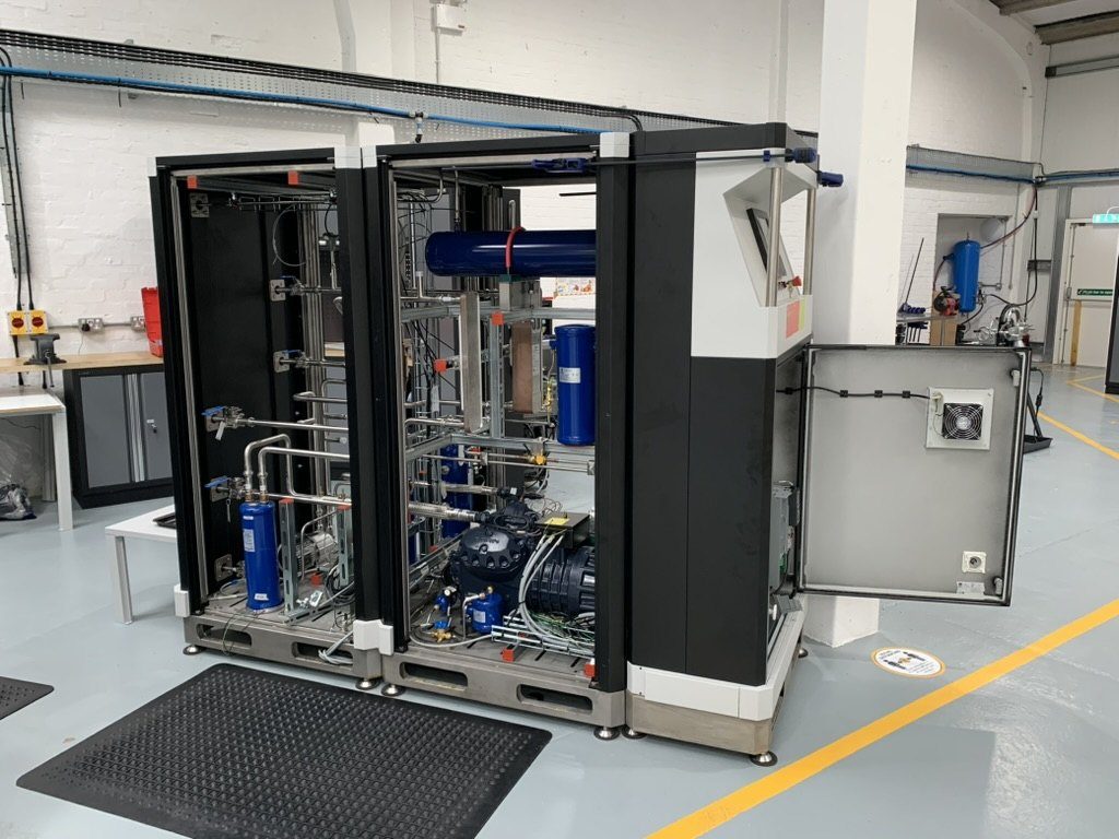 Heat pump cabinet with front panels removed showing receivers, compressor and copper pipework