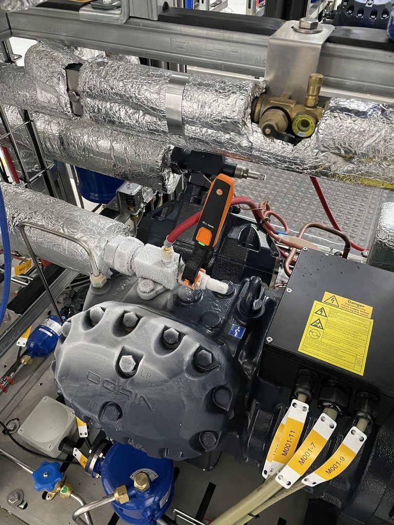 Semi-hermetic compressor with insulated pipework, a temperature probe clipped on and labelled cables